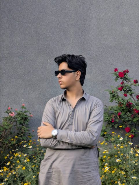 Moaaz Ali in sunglasses standing in front of flowers