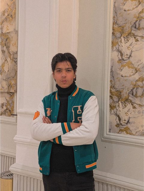 Moaaz Ali in a teal varsity jacket