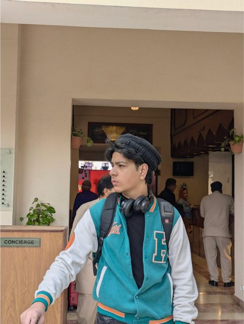 Moaaz Ali wearing headphones and a pakol cap
